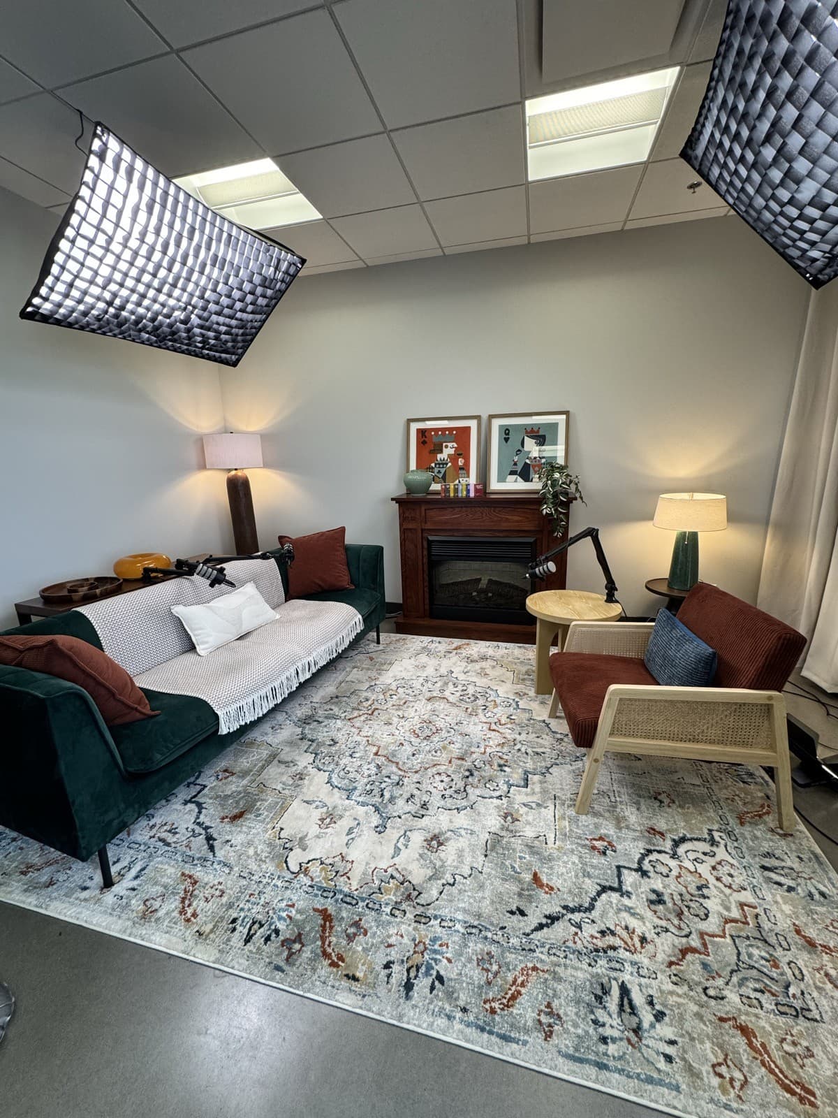 Le set cozy en entier : sofa de velours vert, foyer et tapis à motifs