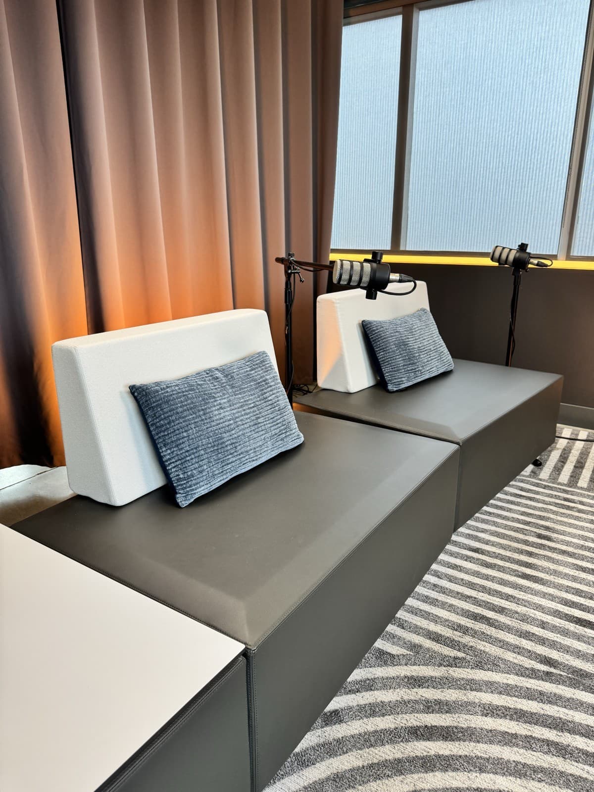 Banquette du set moderne avec rideaux ambrés et éclairage